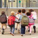 Children running with backpacks on